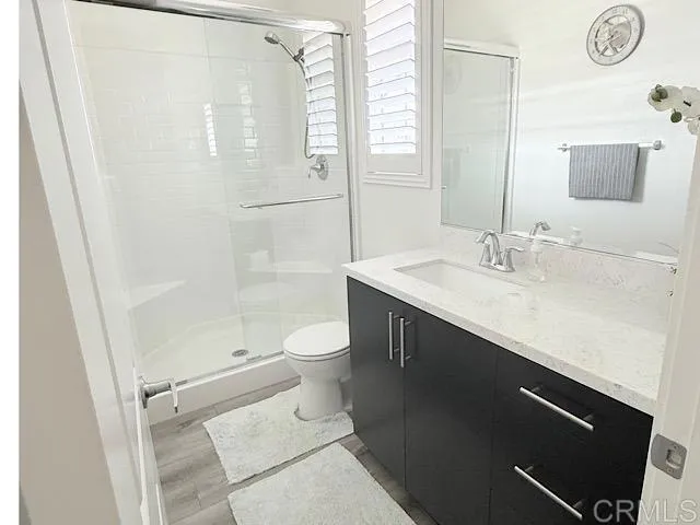 a bathroom with a sink a toilet and shower