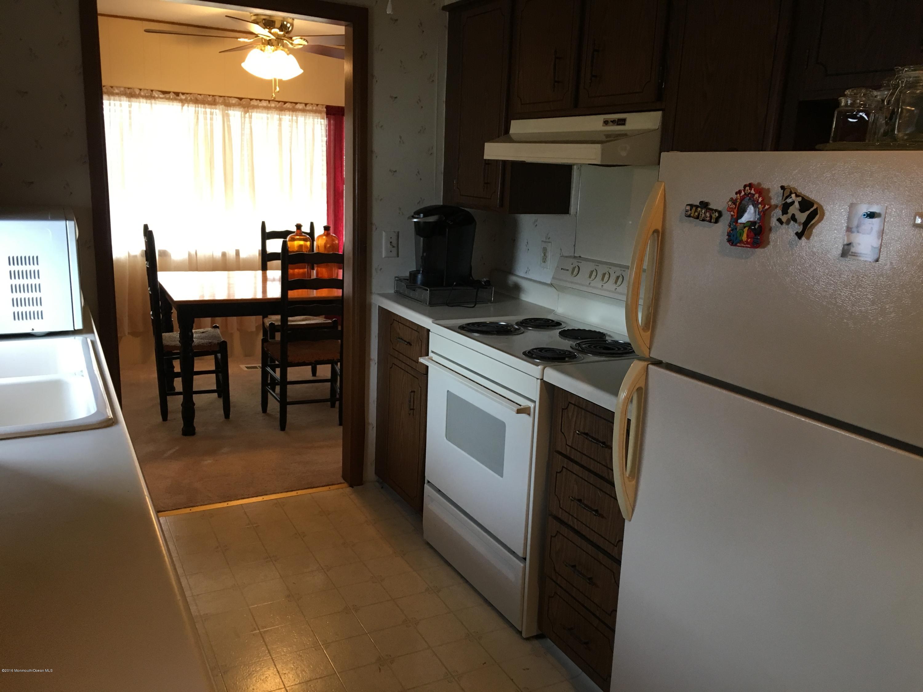 571 Cherin Road Freehold, NJ 07728 - Photo 9 of 17 a kitchen with a refrigerator and a table