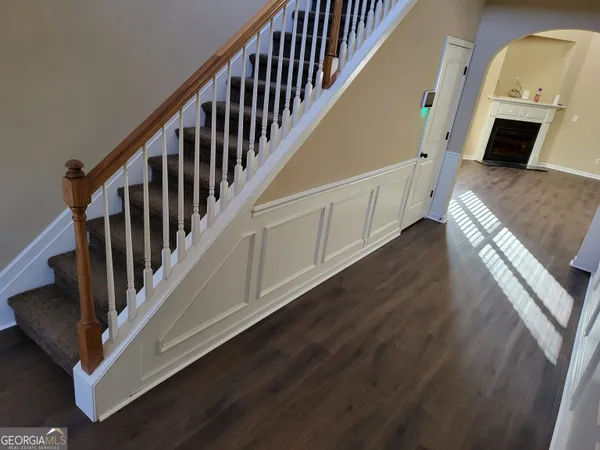 a view of a hallway with wooden floor and staircase