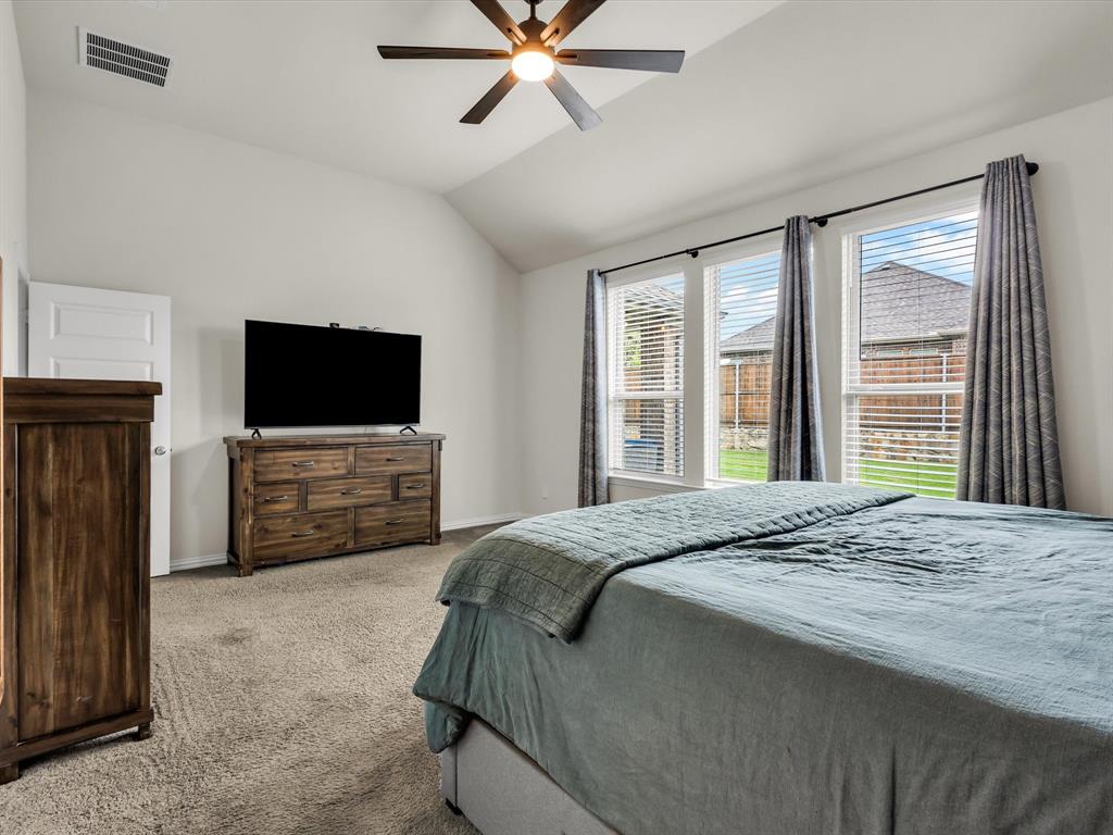 916 Monarch Lane Celina, TX 75009 - Photo 14 of 26 a bedroom with a bed and a flat screen tv