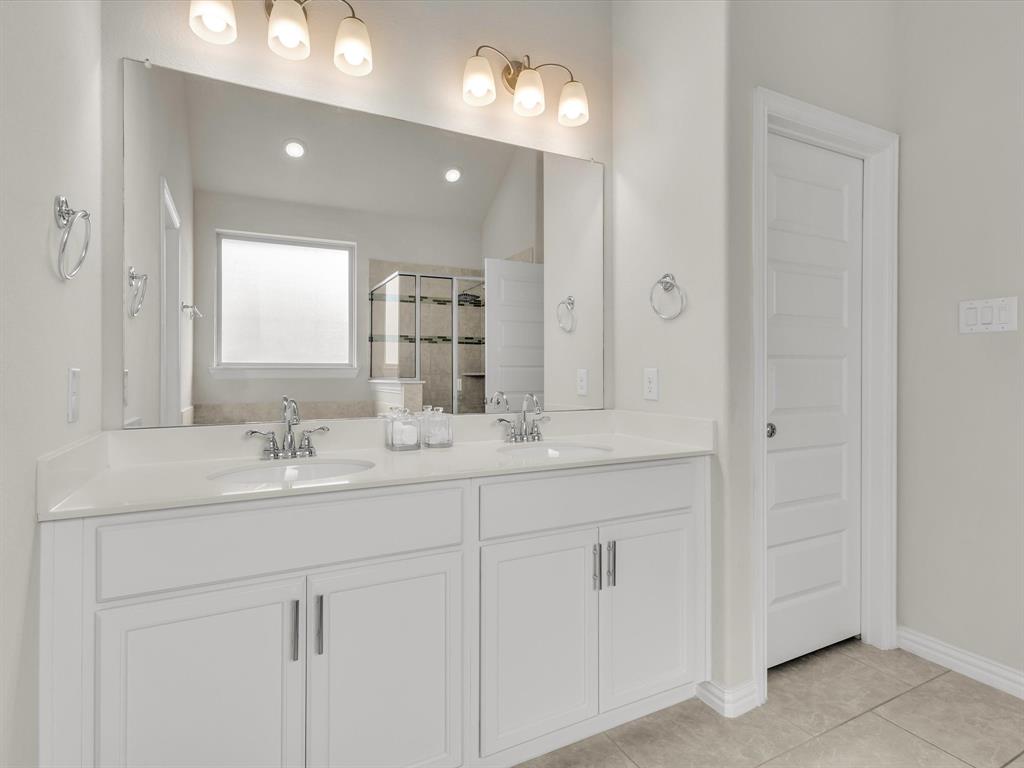 916 Monarch Lane Celina, TX 75009 - Photo 16 of 26 a bathroom with double sink and a mirror