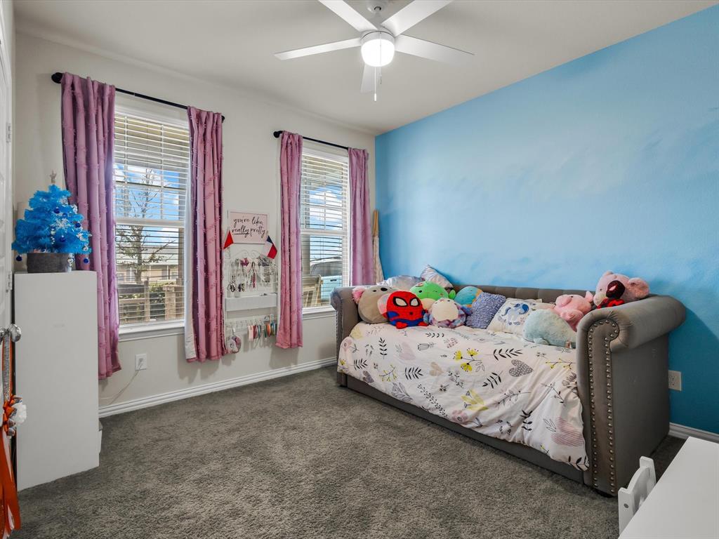 916 Monarch Lane Celina, TX 75009 - Photo 17 of 26 a bedroom with a bed and a chandelier