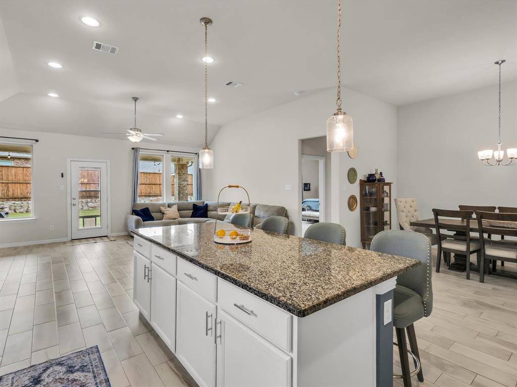 916 Monarch Lane Celina, TX 75009 - Photo 6 of 26 a kitchen with center island table and chairs in it