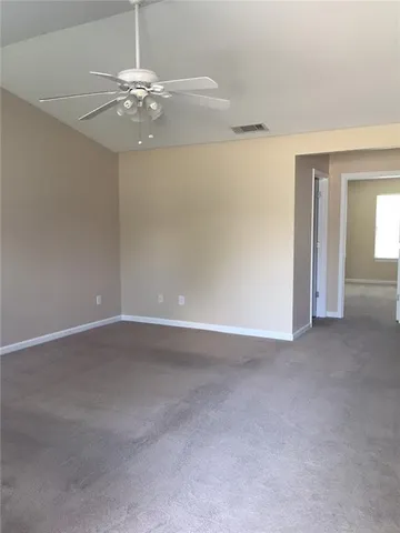 a view of an empty room with a chandelier fan
