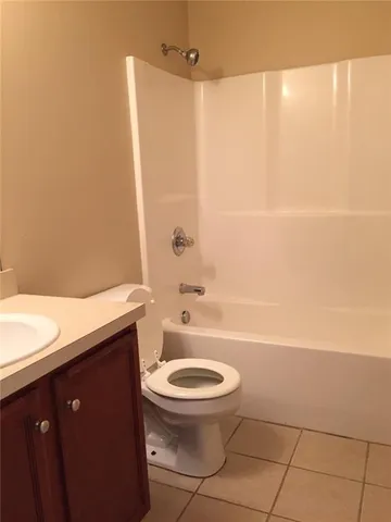 a bathroom with a granite countertop toilet a sink and a shower