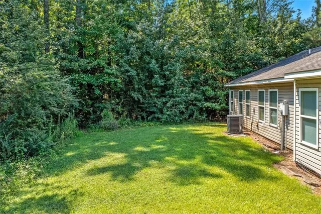 a view of backyard with a garden and large trees