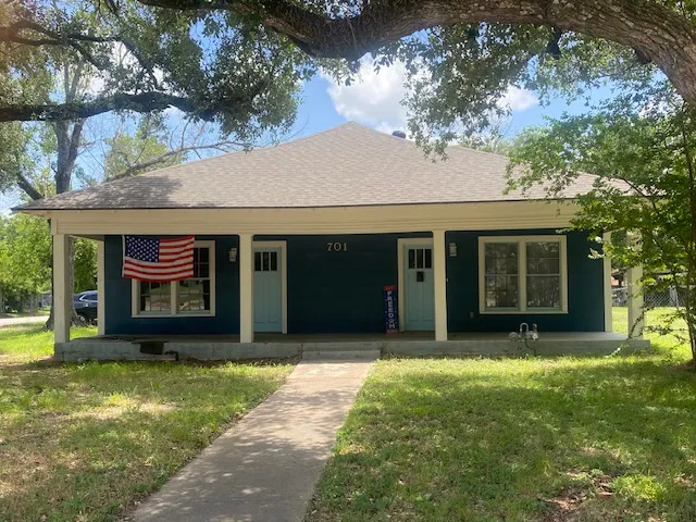 a front view of a house with a garden and yard