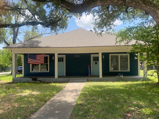 Bungalow with a porch, a front yard, and a shingled roof