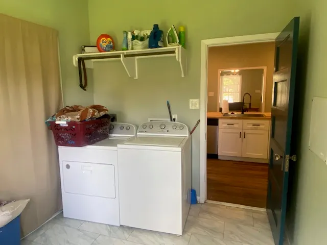 a utility room with sink dryer and washer