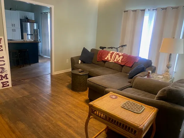 a living room with furniture and a wooden floor