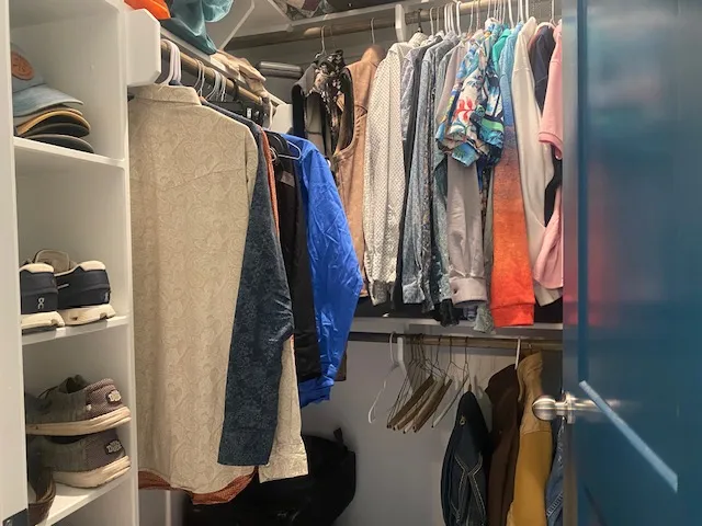 a view of walk in closet with clothes and shoes