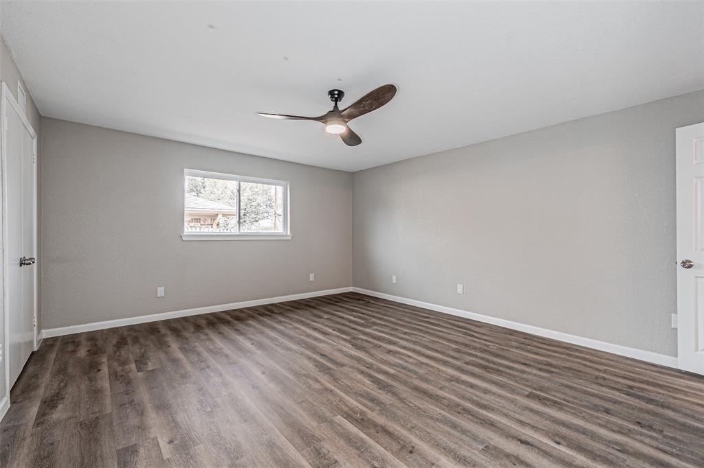1160 Harrison Lane Hurst, TX 76053 - Photo 16 of 34 an empty room with wooden floor ceiling fan and windows
