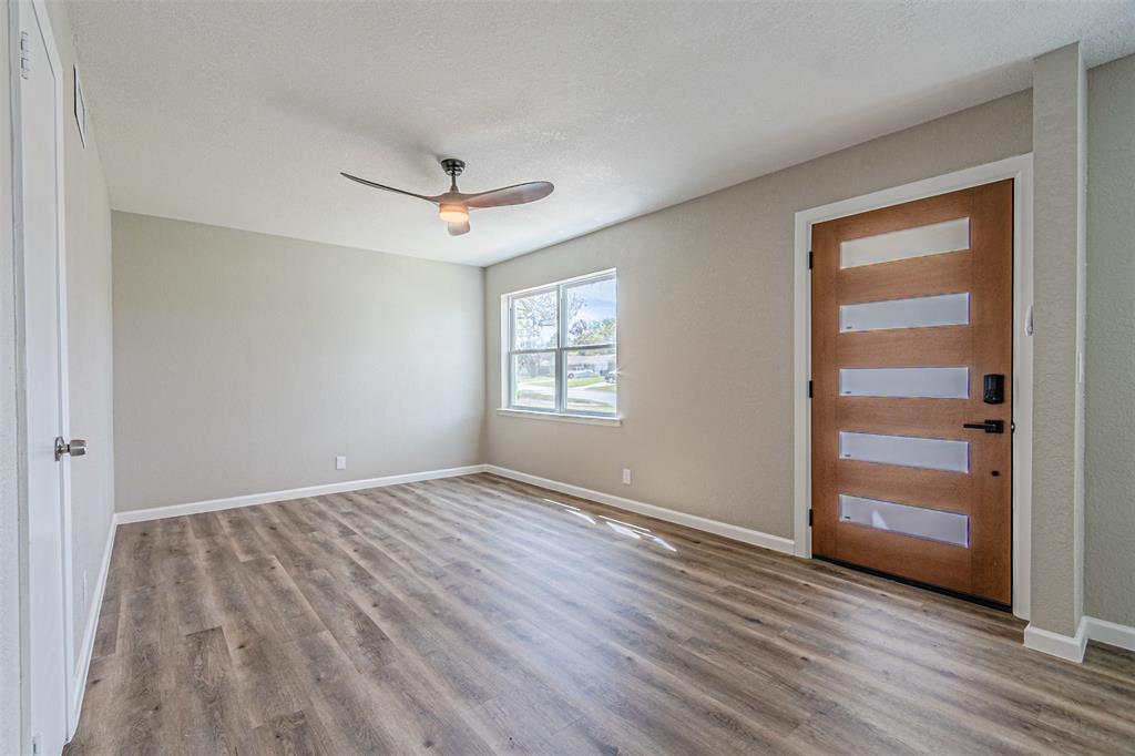 1160 Harrison Lane Hurst, TX 76053 - Photo 7 of 34 wooden floor in an empty room with a window