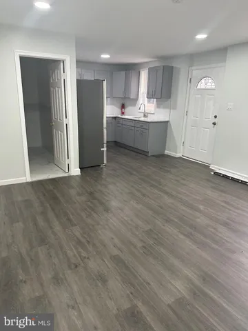 a view of kitchen with refrigerator stove and wooden floor