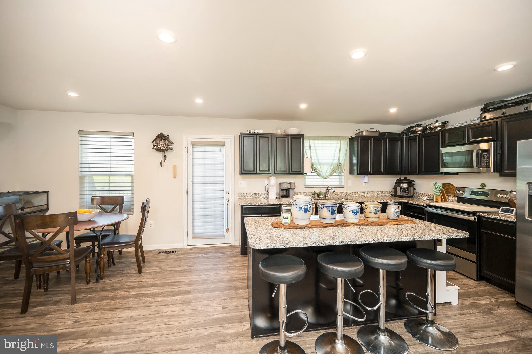 12062 Rundle Crossing King George, VA 22485 - Photo 8 of 67 a kitchen with a dining table chairs and flat screen tv