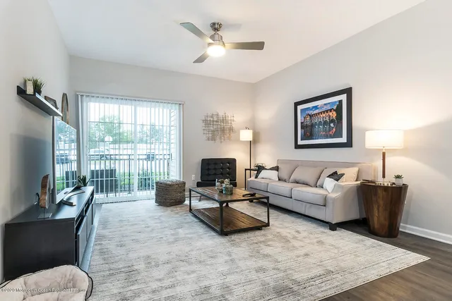 a living room with furniture fireplace and a large window