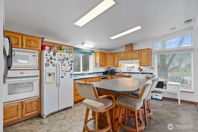a dining room with stainless steel appliances granite countertop a dining table and chairs
