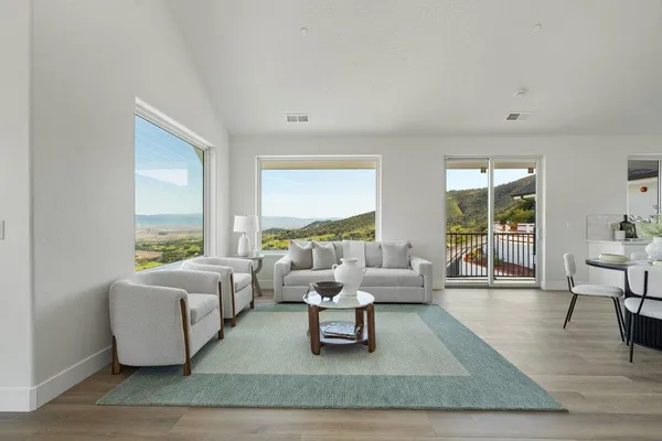 a living room with furniture wooden floor and a large window