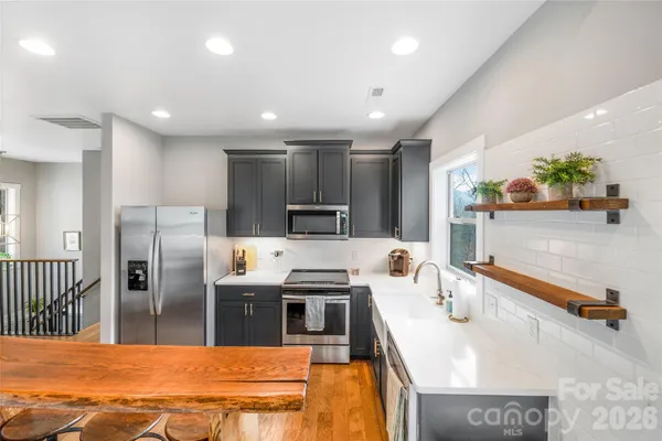 a kitchen with stainless steel appliances kitchen island granite countertop a refrigerator and a stove