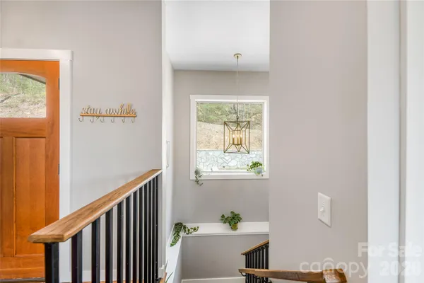 a view of a hallway with a livingroom and a bathroom with bathtub
