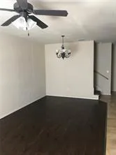 a view of a room with a fan and wooden floor