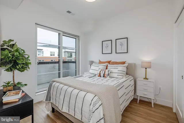 a bedroom with a large bed and a potted plant