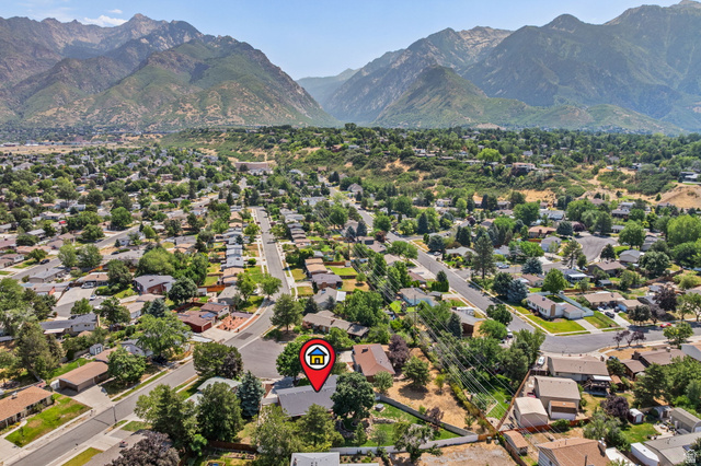 2370 Quail Run Circle East Sandy, UT 84093 - Photo 54 of 54 Aerial perspective showcasing a residential neighborhood with established homes, mature trees, and mountainous terrain in the background