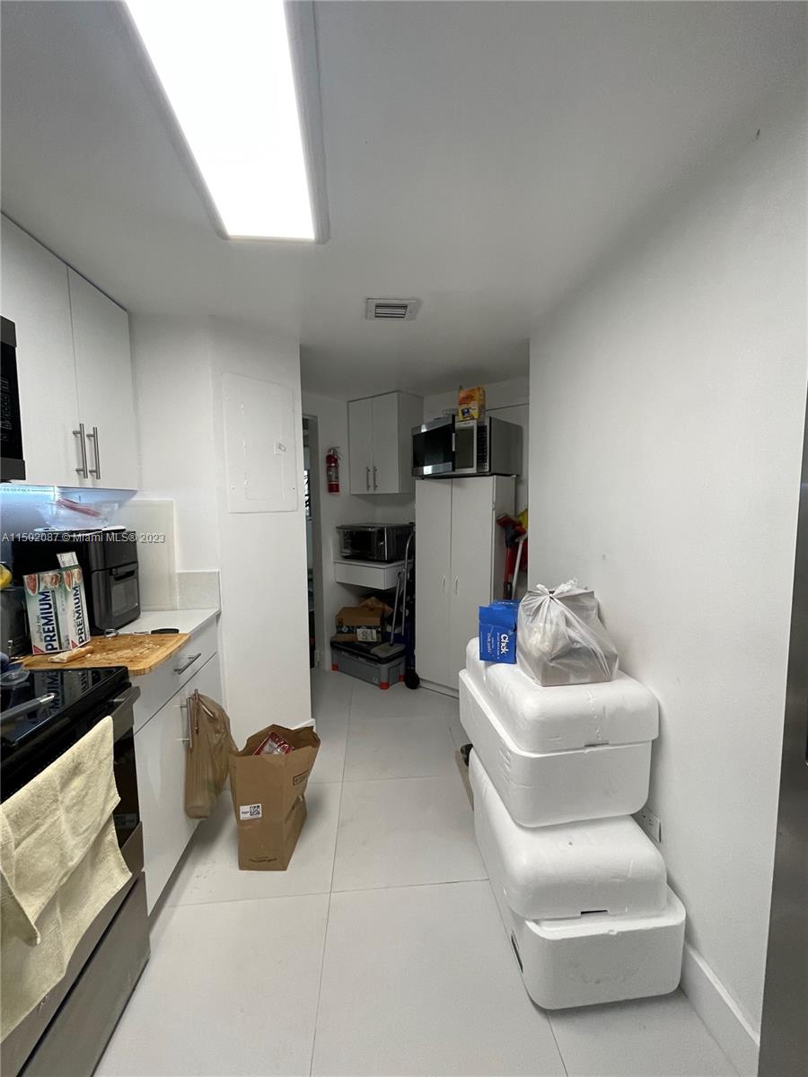 999 Brickell Bay Drive, Unit 1908 Miami, FL 33131 - Photo 37 of 57 a room with furniture and a book shelf