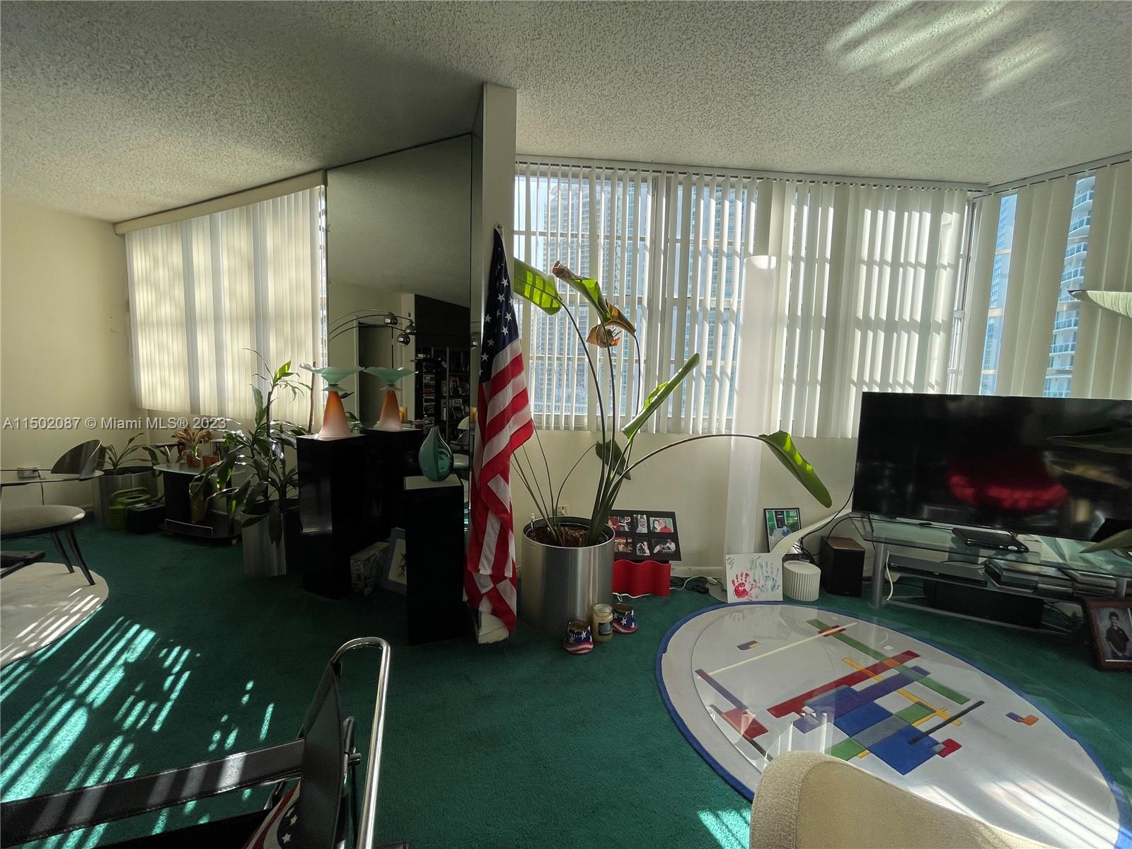 999 Brickell Bay Drive, Unit 1908 Miami, FL 33131 - Photo 45 of 57 a living room with patio furniture and a flat screen tv