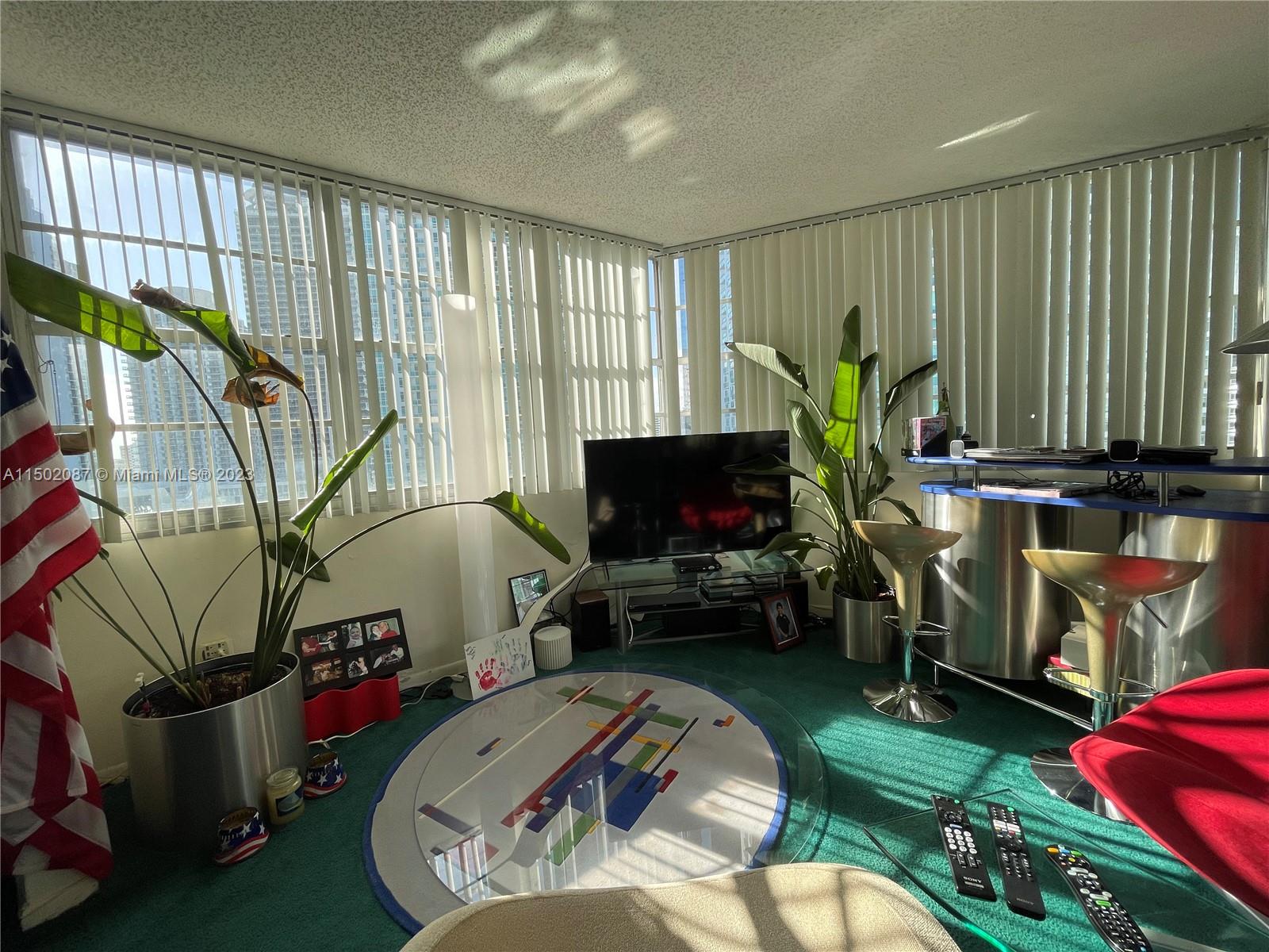 999 Brickell Bay Drive, Unit 1908 Miami, FL 33131 - Photo 46 of 57 a living room with furniture a flat screen tv and a fireplace