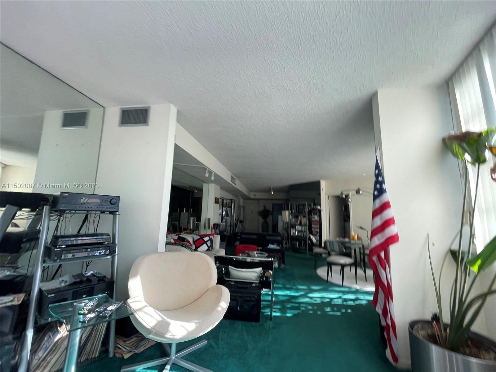 999 Brickell Bay Drive, Unit 1908 Miami, FL 33131 - Photo 48 of 57 a living room with furniture a rug and a flat screen tv