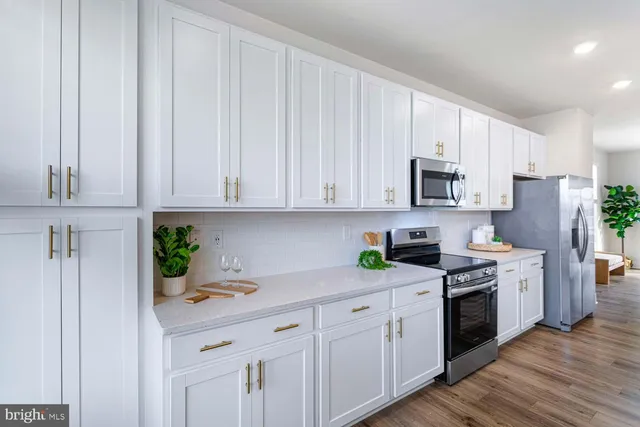 a kitchen with white cabinets and white appliances