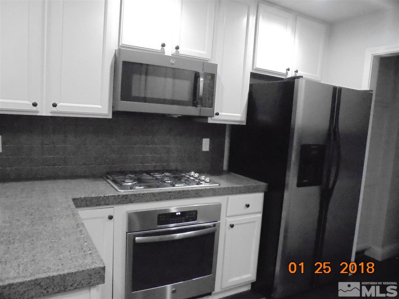 3635 Skyline Boulevard Reno, NV 89509 - Photo 15 of 37 a kitchen with stainless steel appliances granite countertop a stove microwave and refrigerator