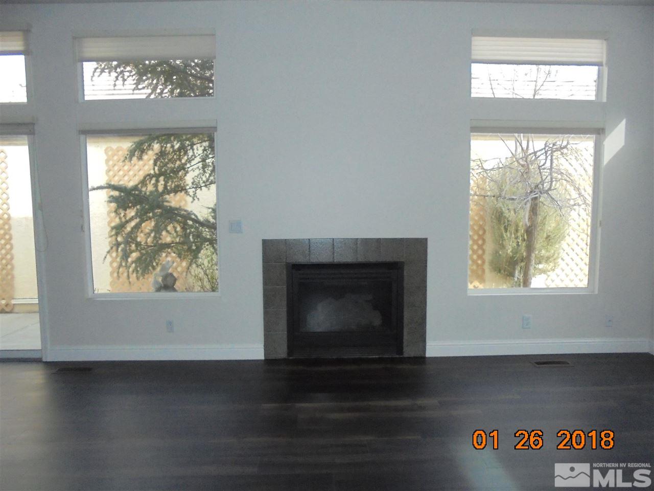 3635 Skyline Boulevard Reno, NV 89509 - Photo 18 of 37 an empty room with wooden floor fireplace and windows