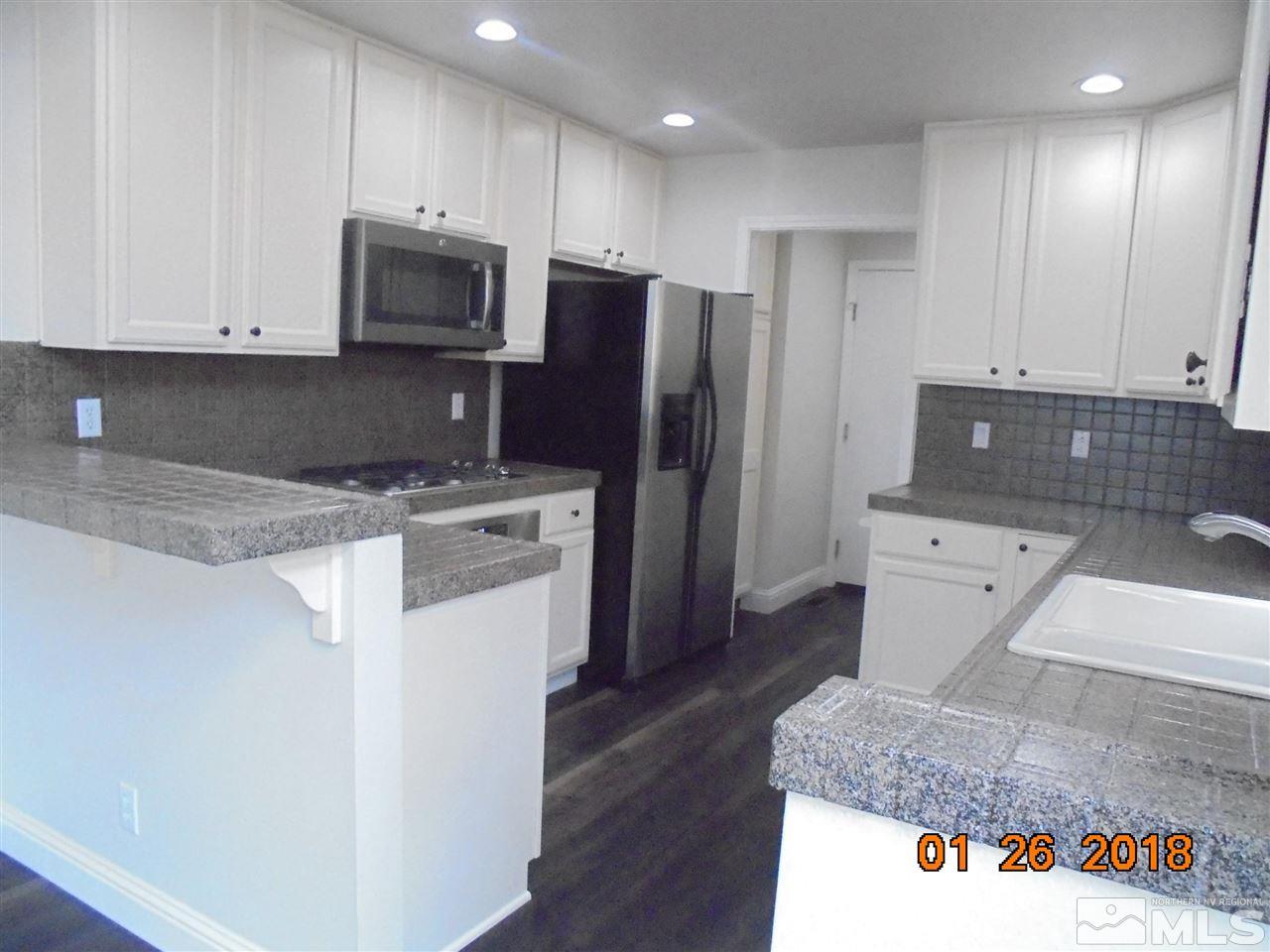 3635 Skyline Boulevard Reno, NV 89509 - Photo 30 of 37 a kitchen with stainless steel appliances granite countertop a refrigerator sink and stove