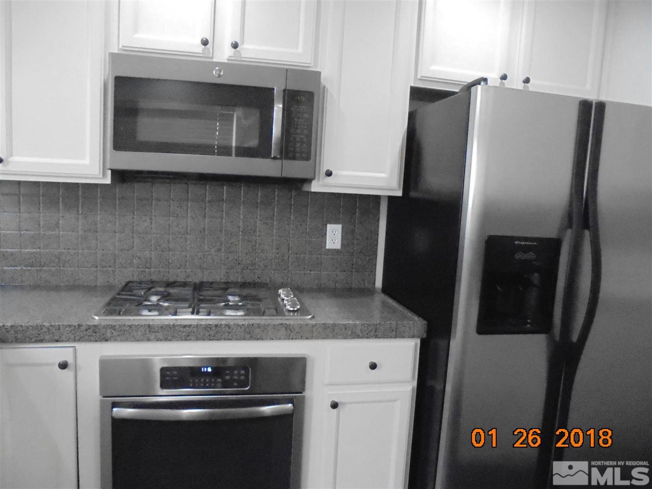 3635 Skyline Boulevard Reno, NV 89509 - Photo 34 of 37 a kitchen with stainless steel appliances granite countertop a refrigerator stove and microwave