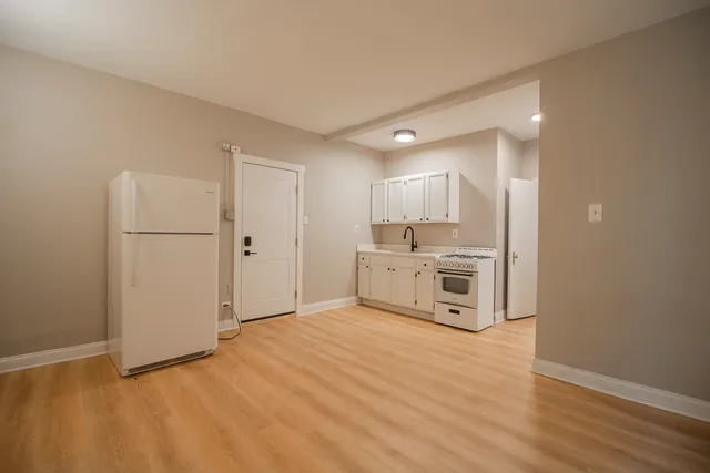 a large white kitchen with cabinets and a refrigerator