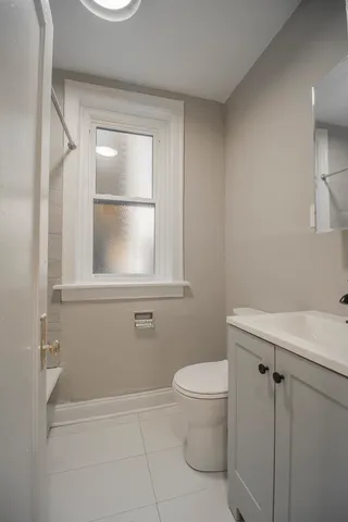 a bathroom with a toilet a sink and a window