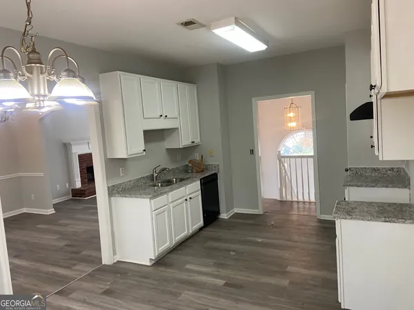 a kitchen with granite countertop a sink and a stove top oven