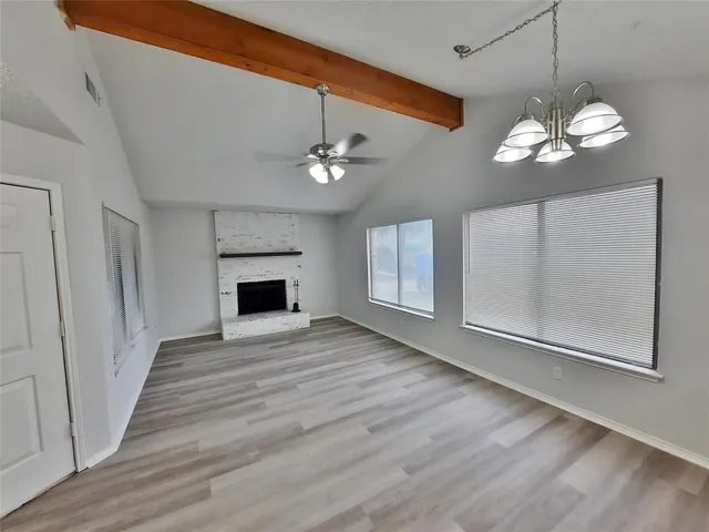 a view of a livingroom with a fireplace a chandelier and wooden floor