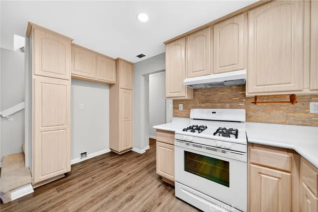 a kitchen with granite countertop wooden cabinets and white appliances