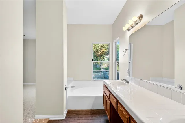 a bathroom with a tub sink and mirror