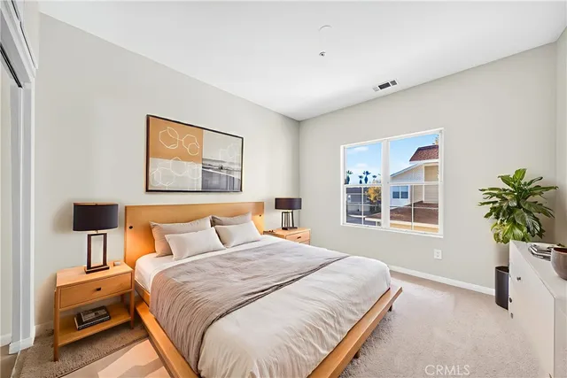 a bedroom with bed and paintings on the wall