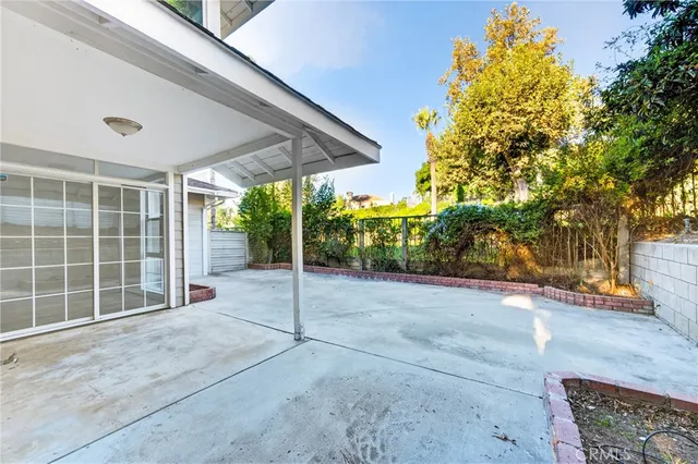 a view of a white house with large windows and a small yard