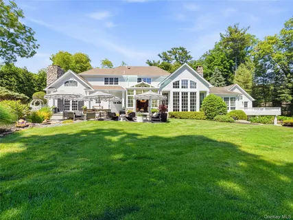 a front view of a house with a garden and trees
