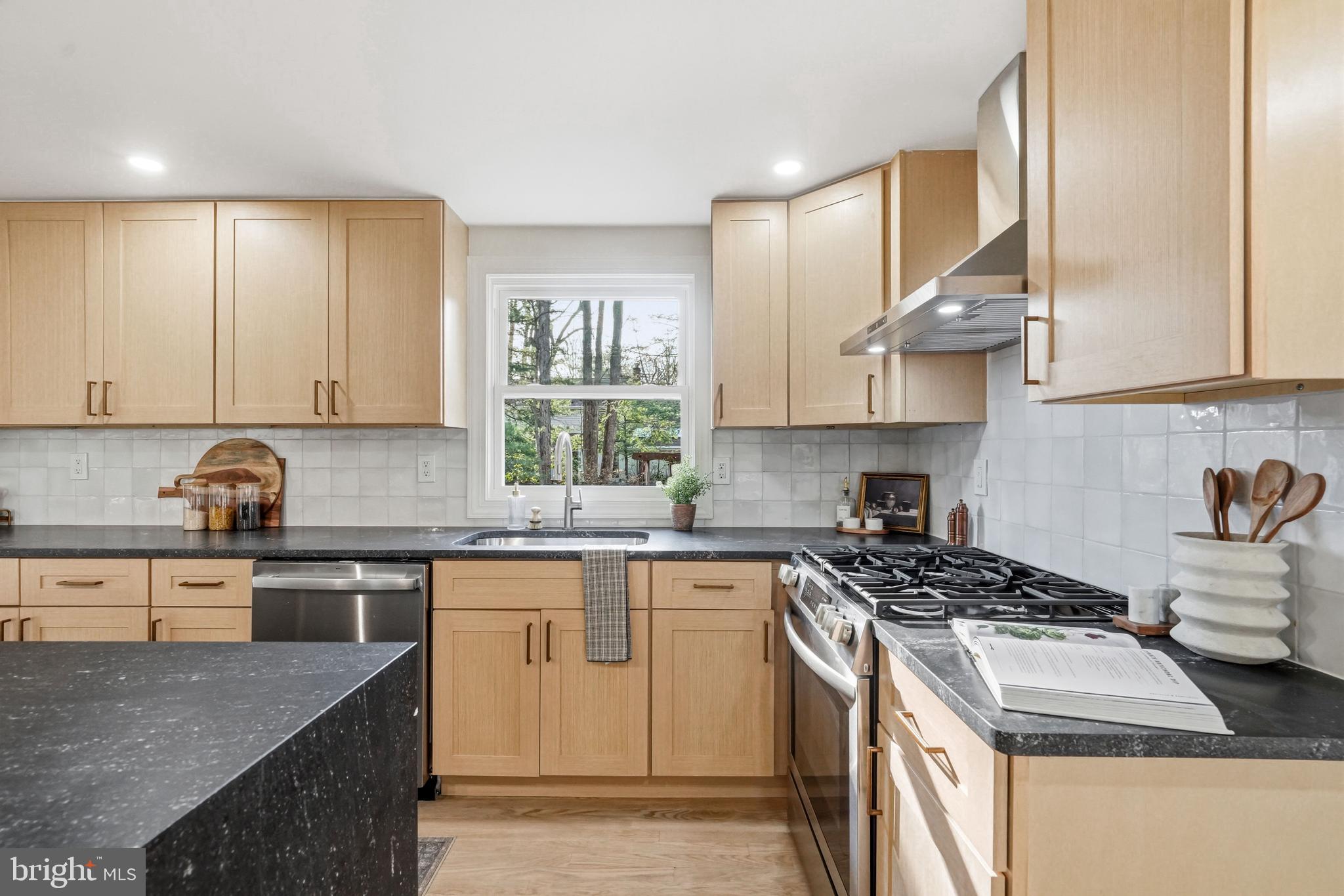 1309 Marlkress Road Cherry Hill, NJ 08003 - Photo 17 of 57 a kitchen with stainless steel appliances granite countertop a stove a sink dishwasher and cabinets with wooden floor