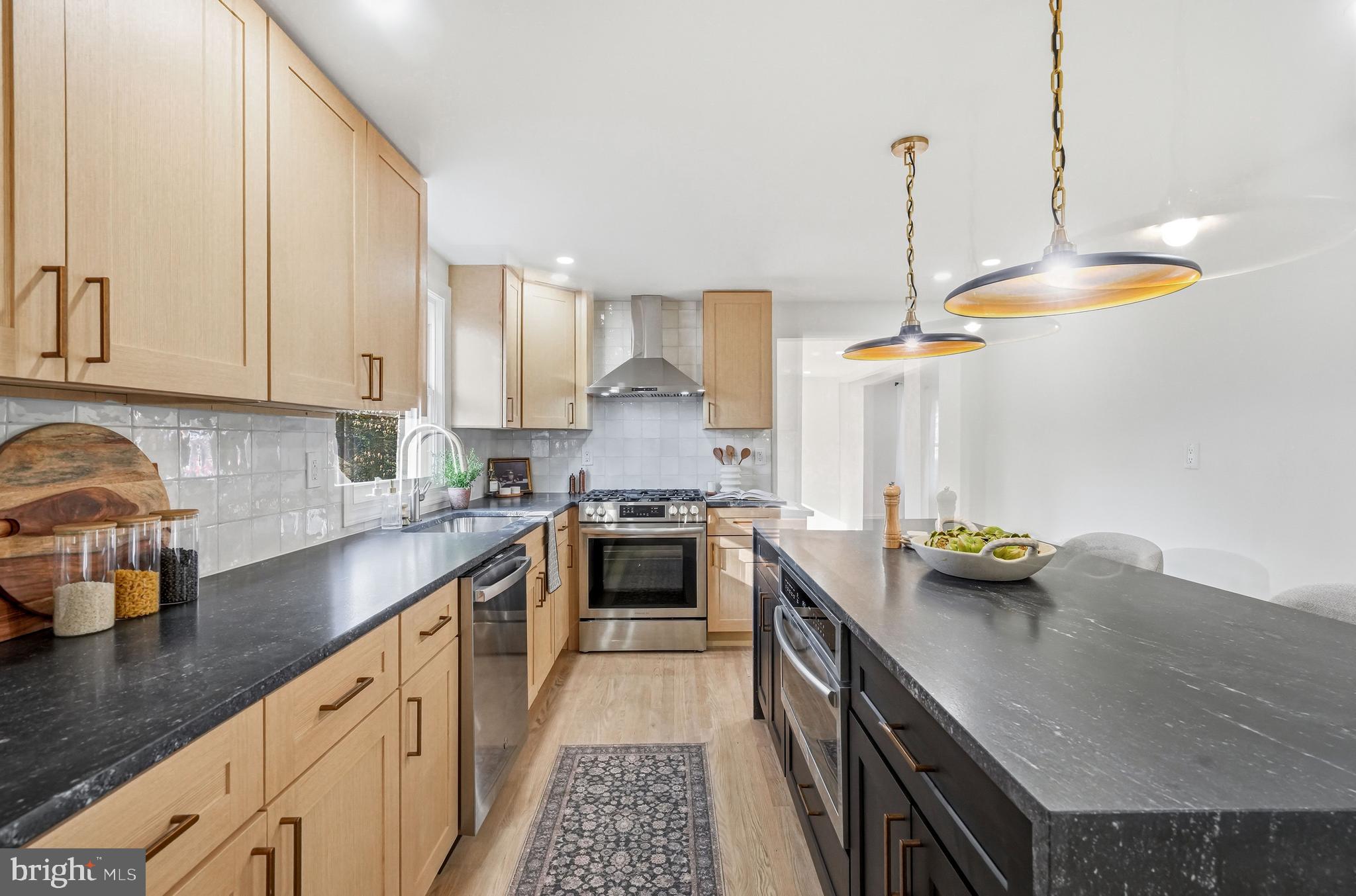 1309 Marlkress Road Cherry Hill, NJ 08003 - Photo 21 of 57 a kitchen with stainless steel appliances granite countertop a sink a stove and a wooden floor