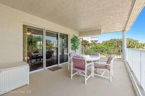 a dining room with furniture and a floor to ceiling window