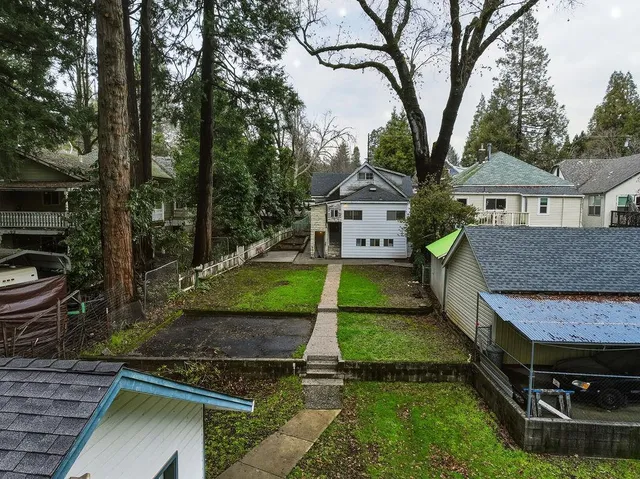 a view of a house with backyard and trees