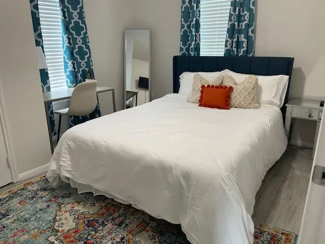 a large bed sitting in a bedroom next to a window and chair